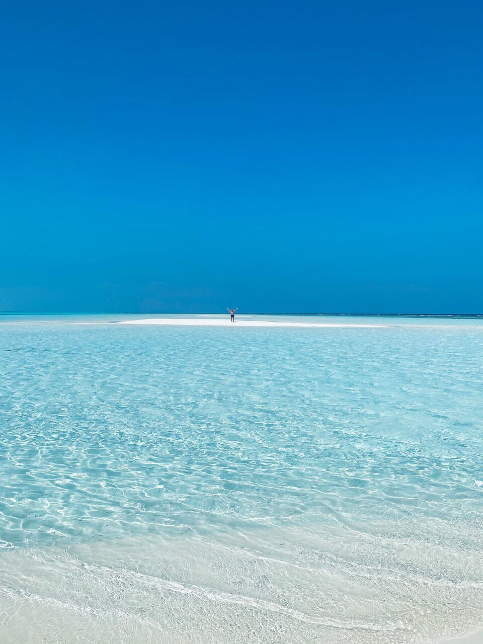 Solo traveler celebrating on an empty sandbank