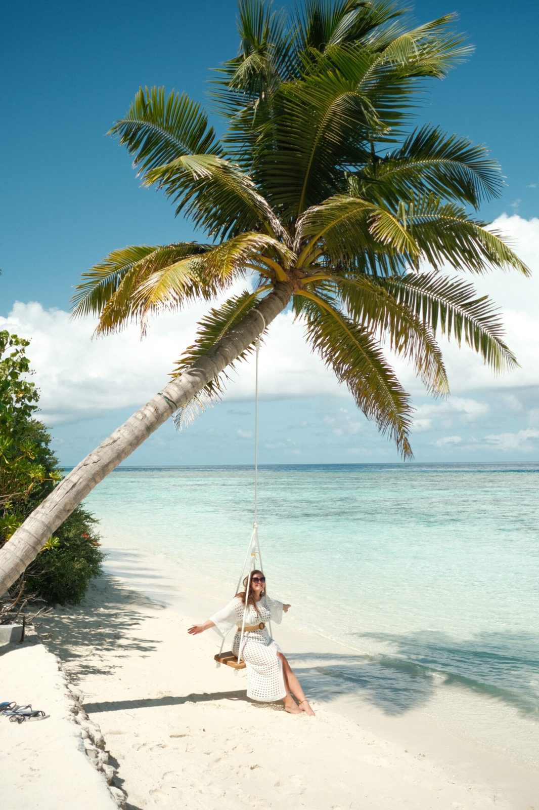 Woman on a palm-tree swing on a local island beach